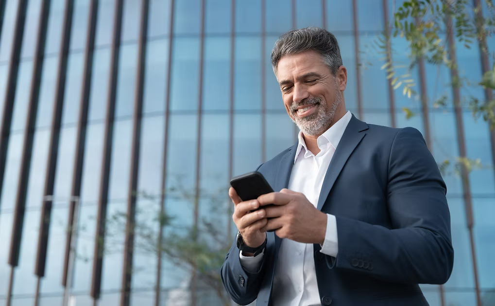 A business owner checking his numbers on his phone
